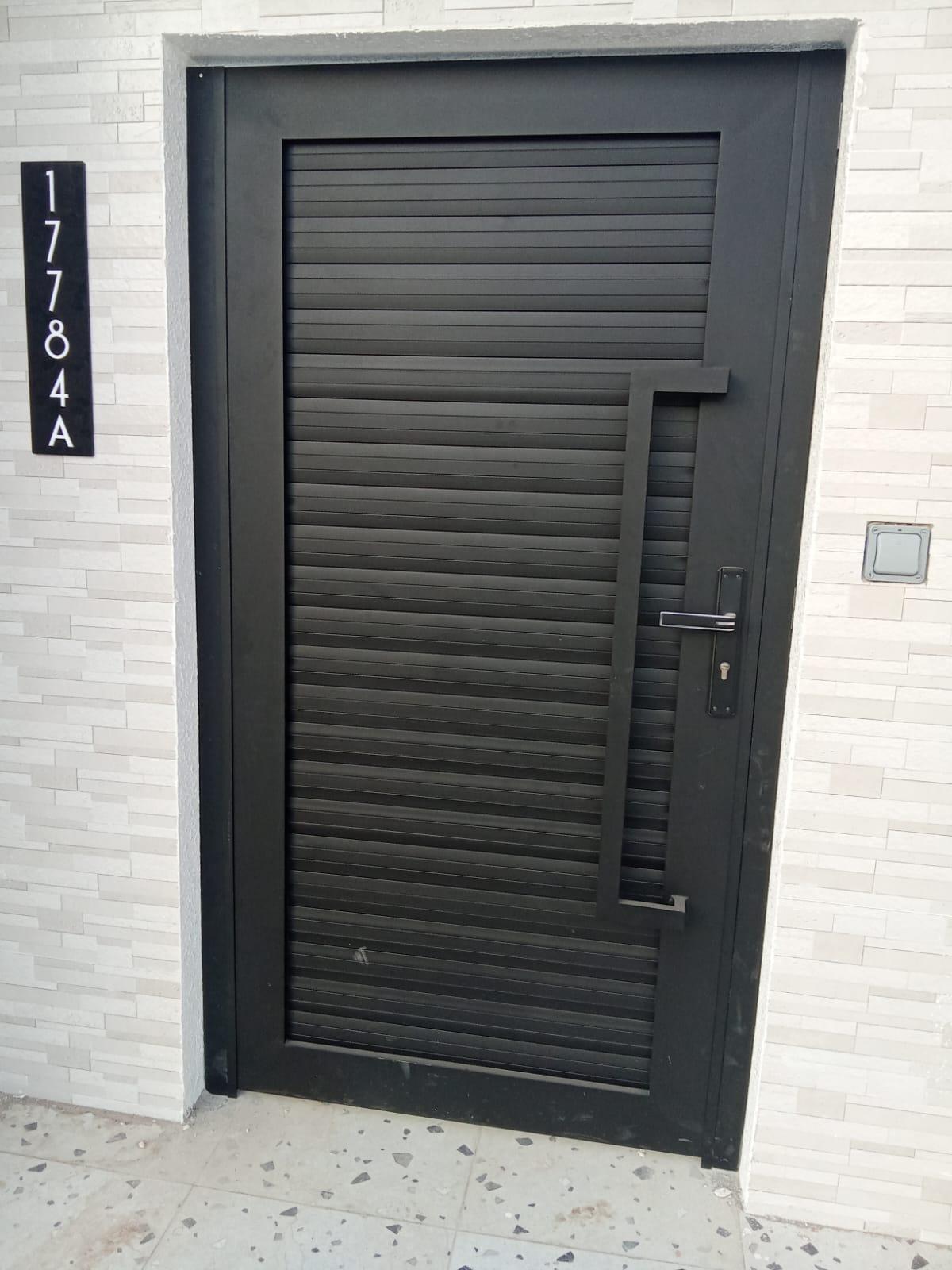 Matte black aluminium slatted villa door installed in Oman