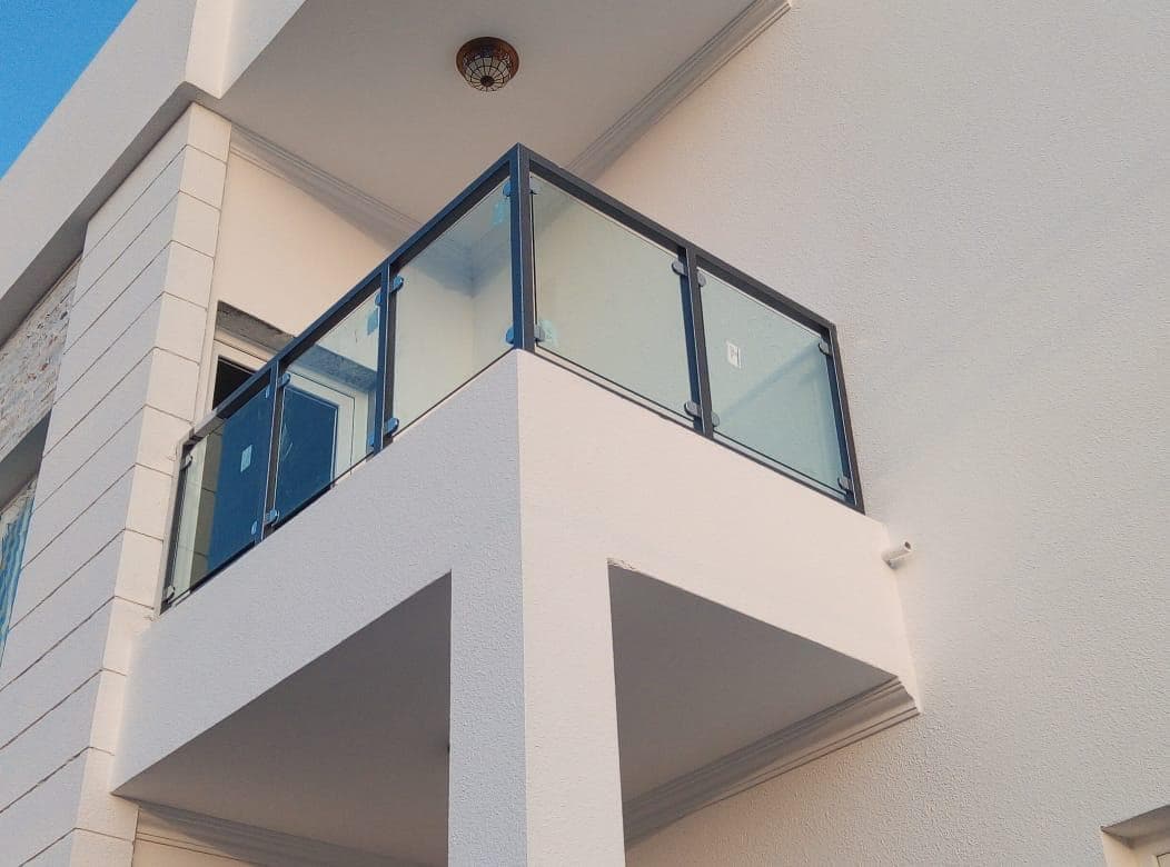 Clear balcony glass railing in a dark aluminium frame, Oman villa