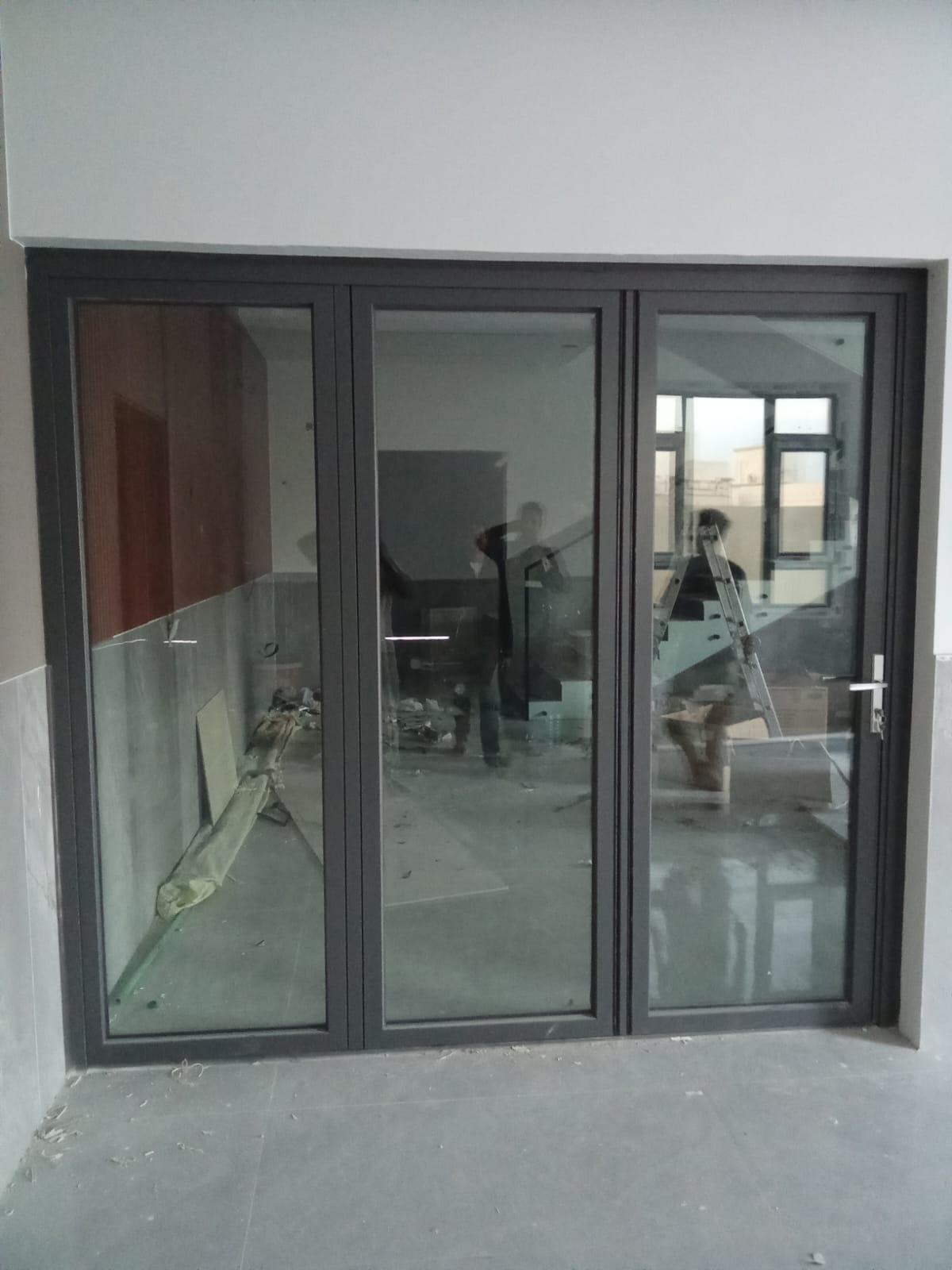 Three-panel dark-frame office glass door system in Muscat