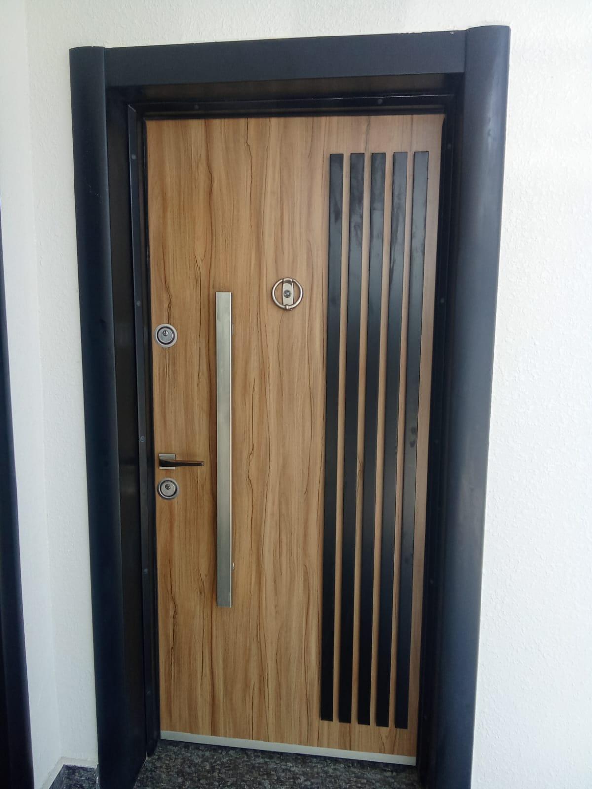 Wood-grain aluminium entry door with black frame in Muscat